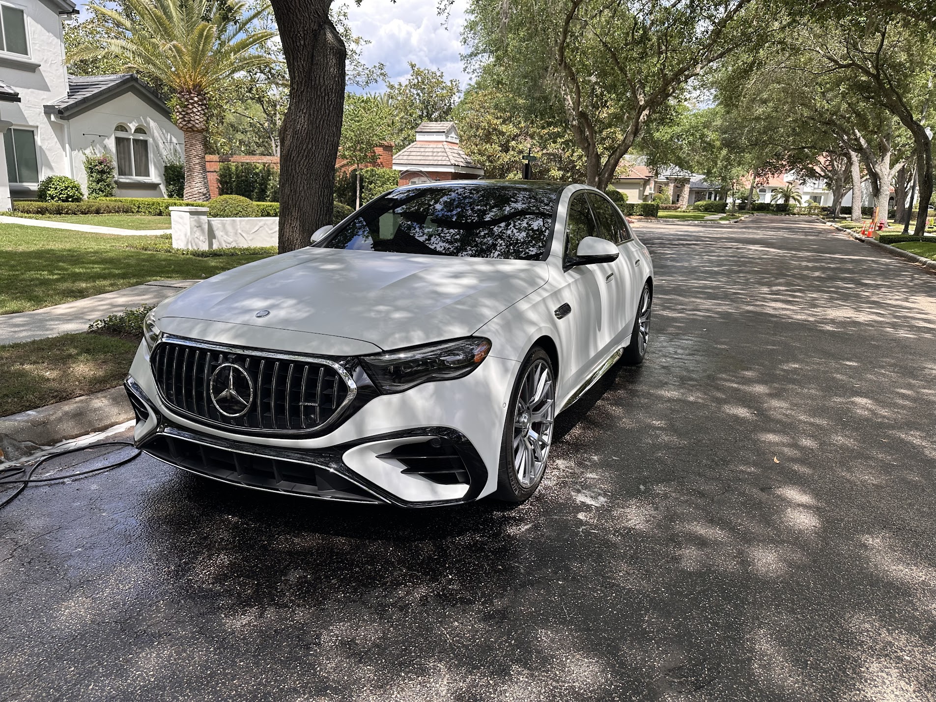 Freshly detailed Mercedes-AMG sedan in a tree-lined driveway